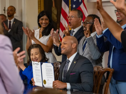 The room erupts in cheers after Maryland Governor Wes Moore displays a historic executive order pardoning more than 175,000 cannabis-related misdemeanor convictions. (Jerry Jackson/Staff)