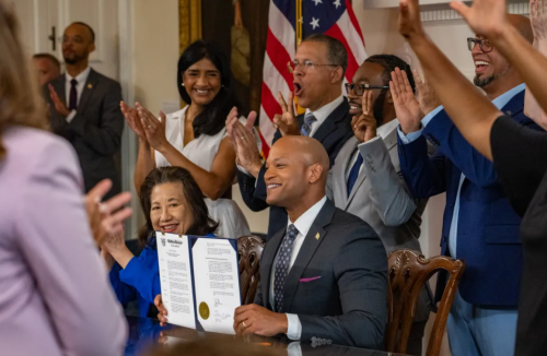 The room erupts in cheers after Maryland Governor Wes Moore displays a historic executive order pardoning more than 175,000 cannabis-related misdemeanor convictions. (Jerry Jackson/Staff)