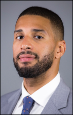 Close up headshot of young man in a grey suit